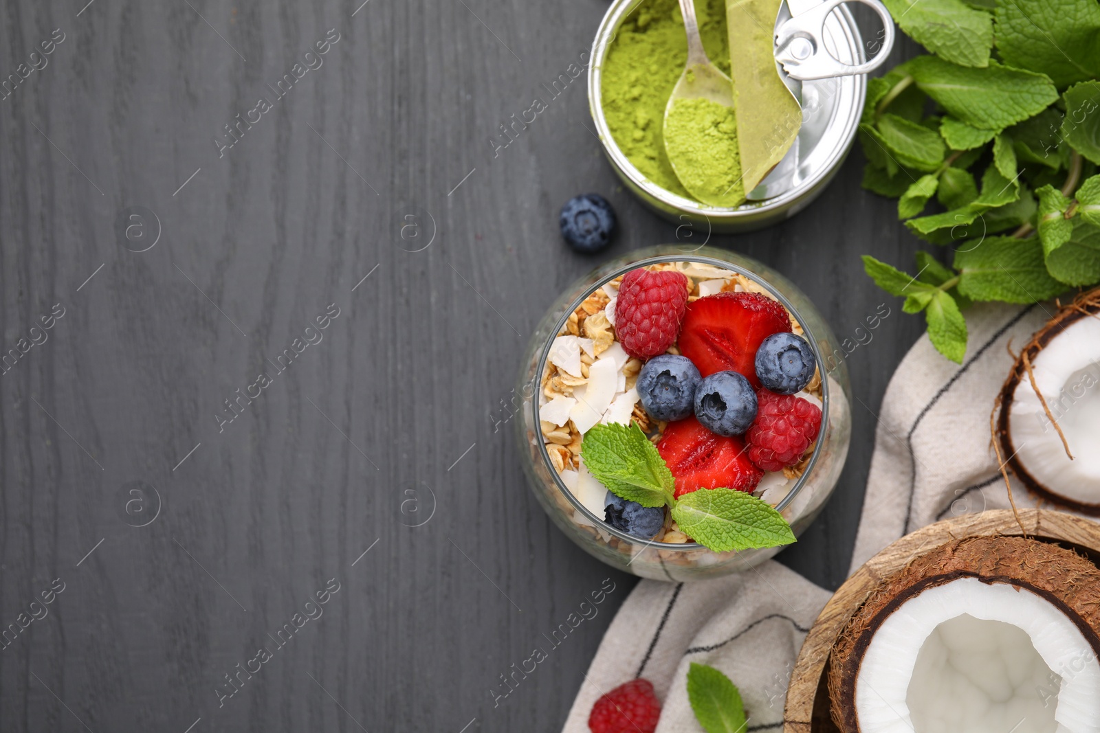 Photo of Tasty oatmeal with berries and mint on black wooden table, flat lay. Space for text. Healthy breakfast