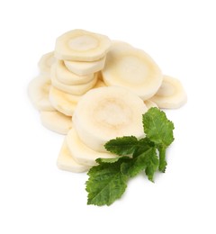 Photo of Cut fresh ripe parsnip with leaves on white background