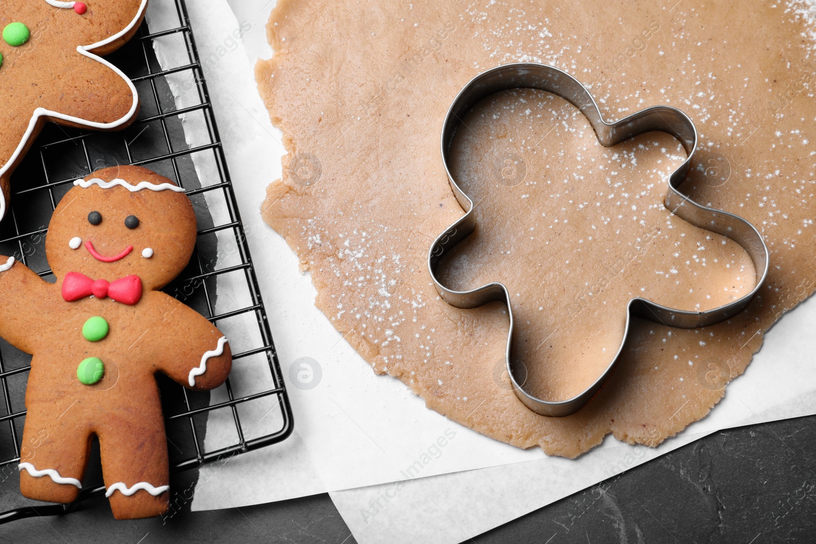 Photo of Flat lay composition with homemade gingerbread man cookies on black table