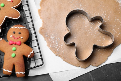 Photo of Flat lay composition with homemade gingerbread man cookies on black table