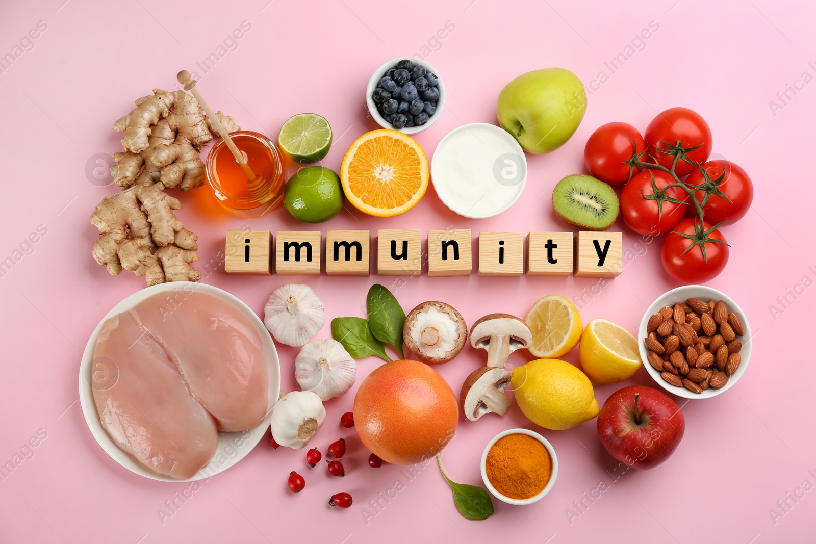 Photo of Set of natural products and cubes with word Immunity on pink background, flat lay