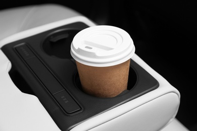 Photo of Takeaway paper coffee cup in holder inside car