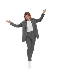 Beautiful businesswoman in suit walking on white background