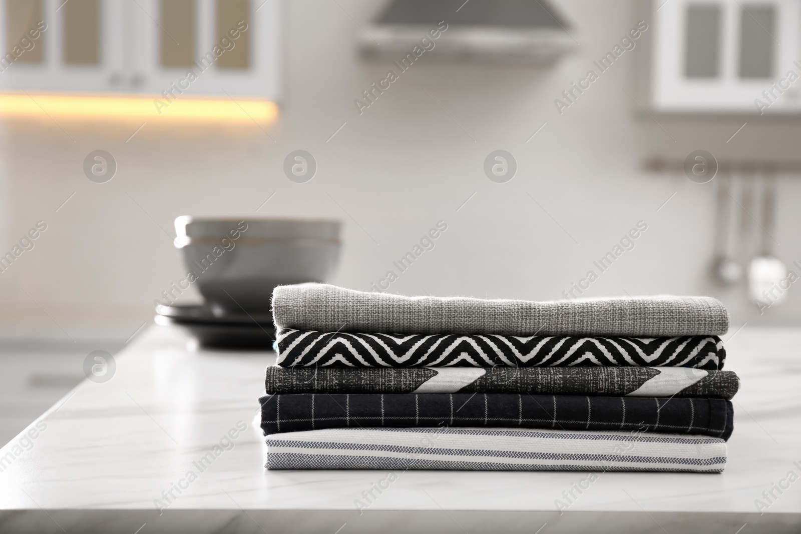 Photo of Stack of soft kitchen towels on white table indoors