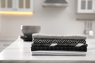 Photo of Stack of soft kitchen towels on white table indoors