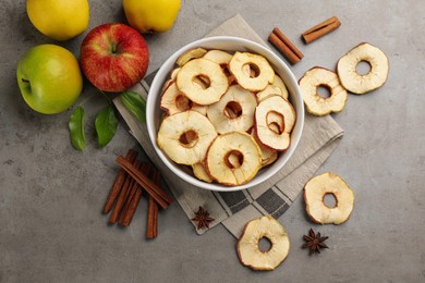 Photo of Delicious apple chips, fresh fruits, anise and cinnamon on grey table, flat lay
