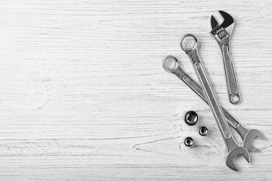 Photo of Auto mechanic's tools on white wooden background, flat lay. Space for text