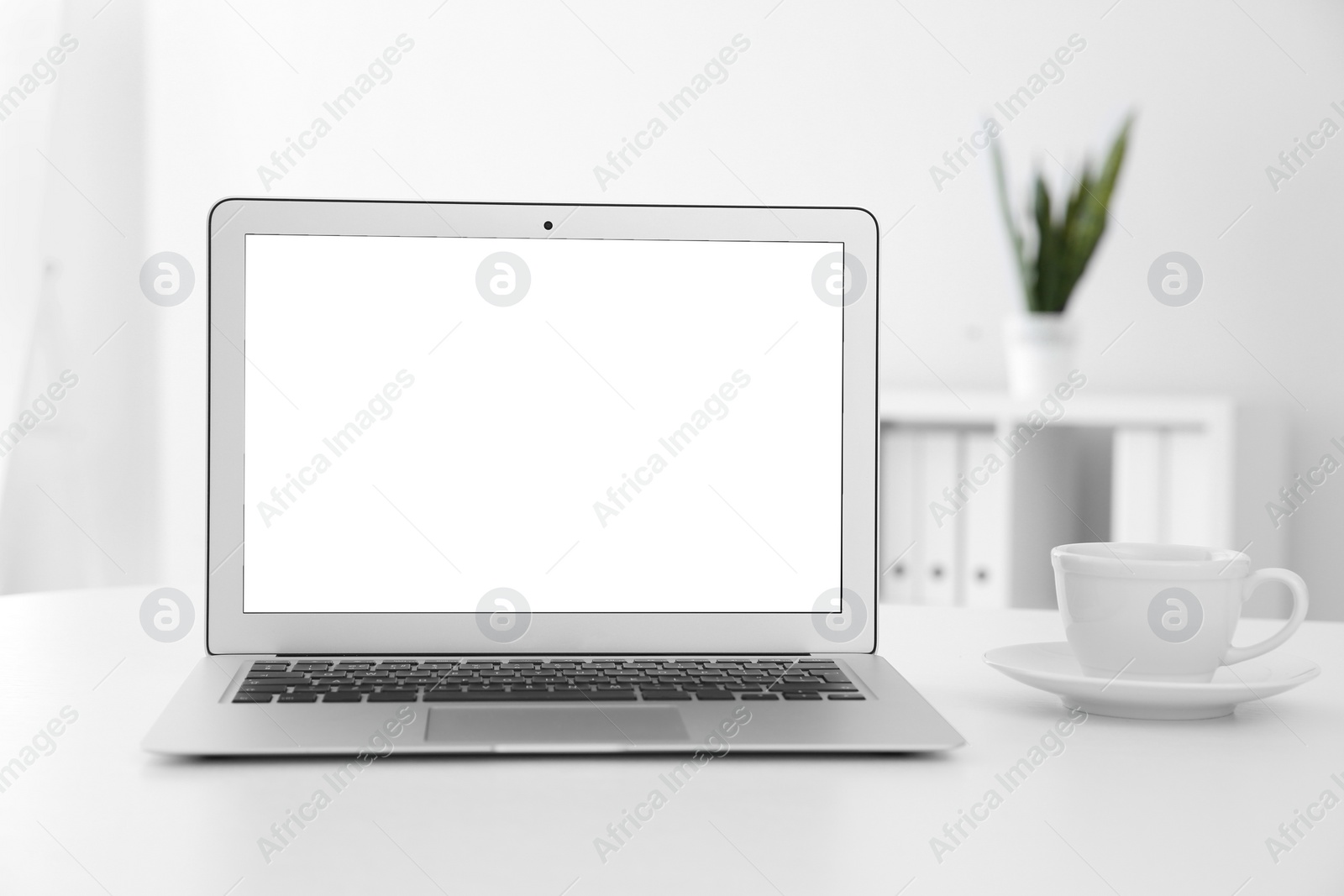 Photo of Comfortable workplace with modern laptop on table in office. Mockup for design