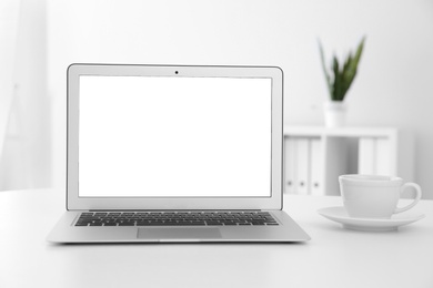 Photo of Comfortable workplace with modern laptop on table in office. Mockup for design