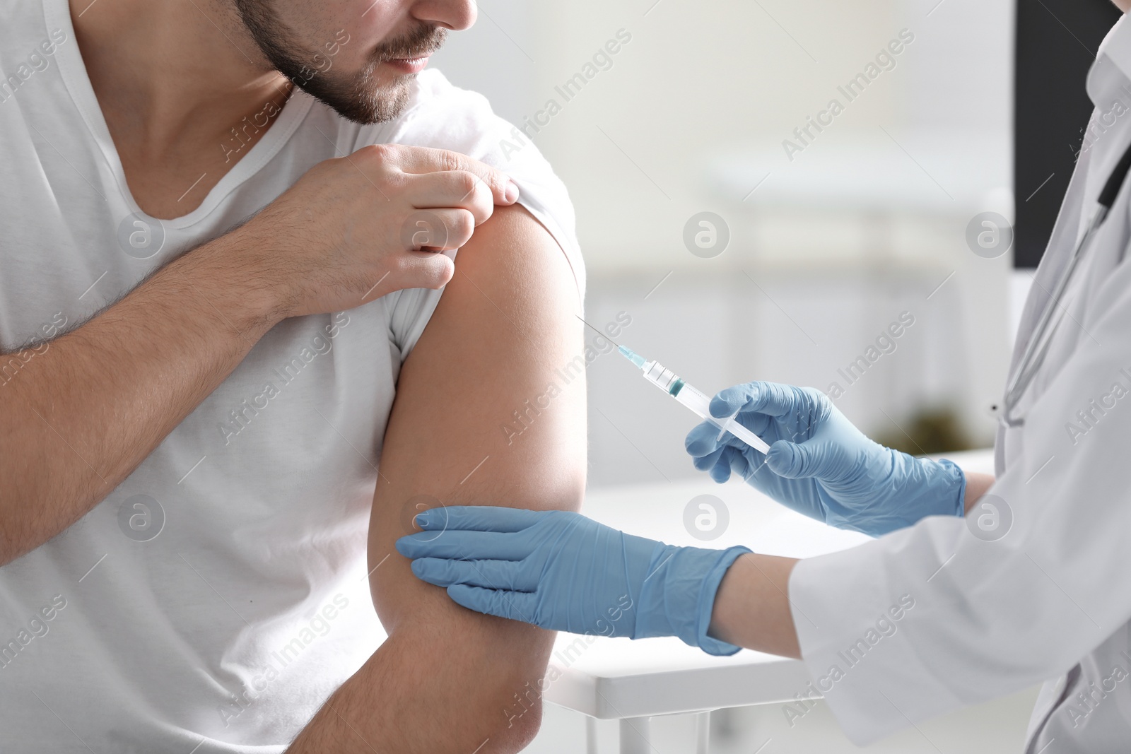 Photo of Doctor giving injection to patient in hospital, closeup. Vaccination concept