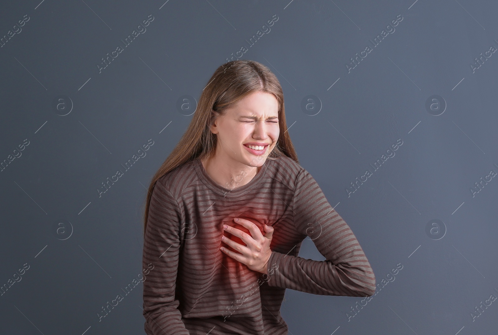 Photo of Young woman having heart attack on gray background