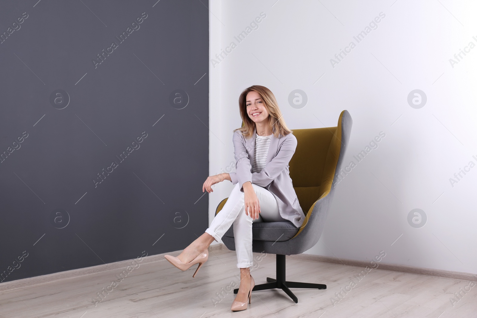 Photo of Young woman sitting in armchair at home. Space for text