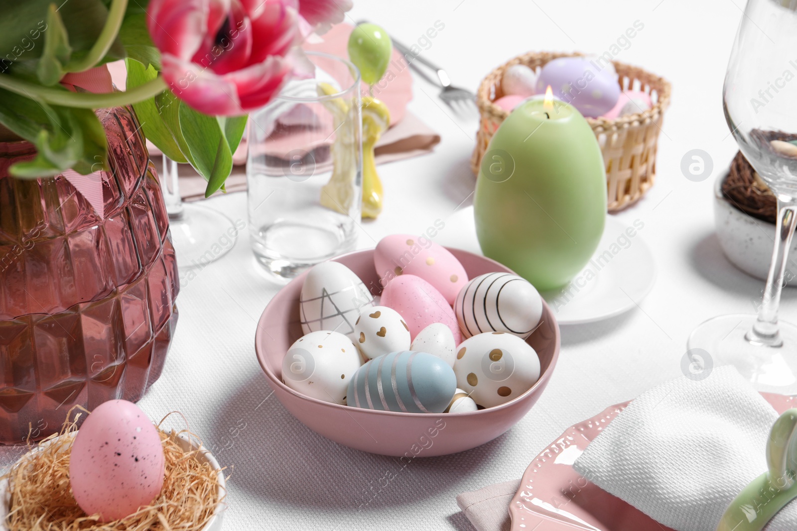 Photo of Festive table setting with painted eggs. Easter celebration