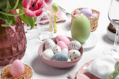 Photo of Festive table setting with painted eggs. Easter celebration