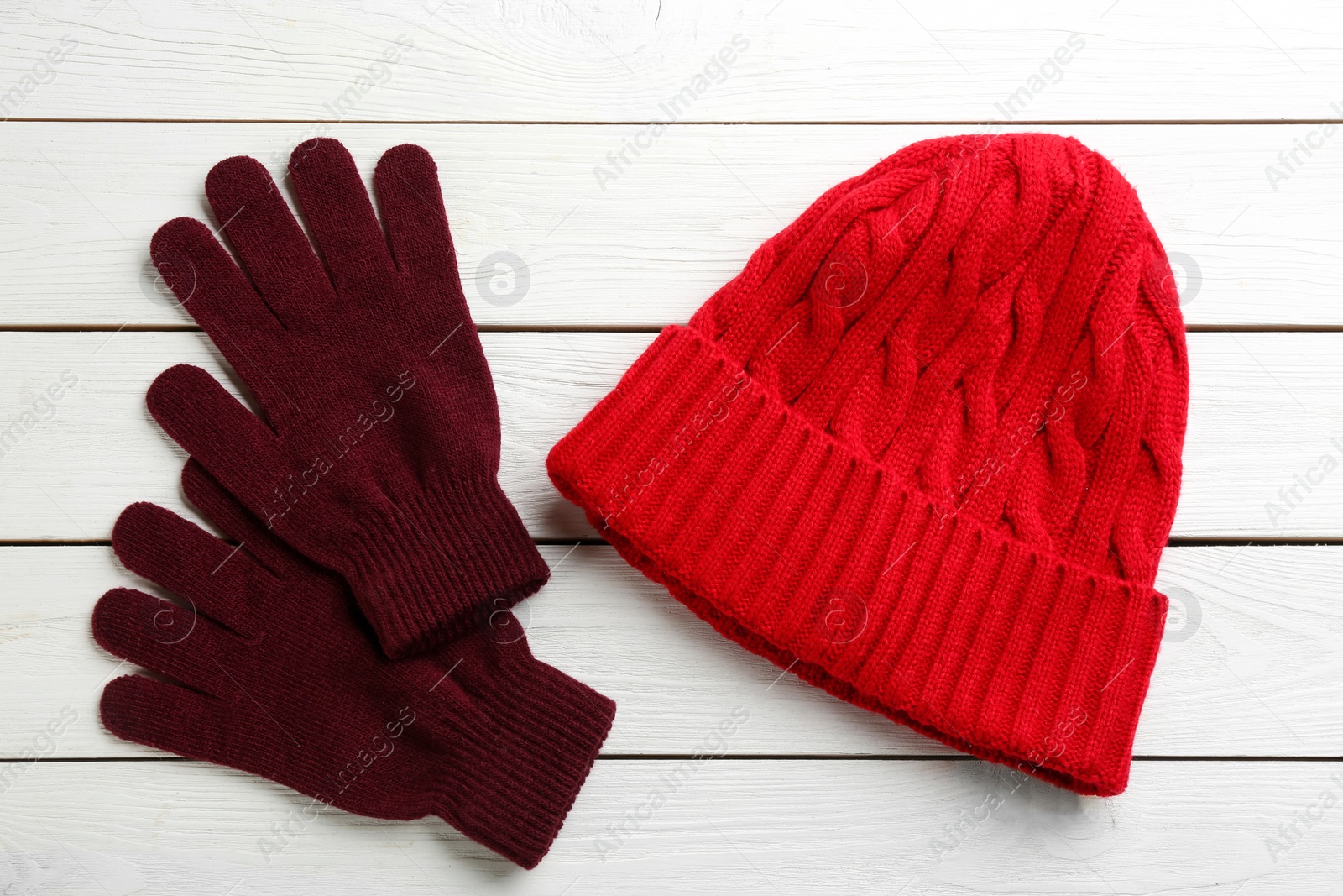 Photo of Stylish gloves and hat on white wooden background, flat lay