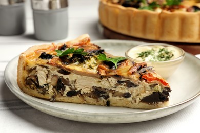 Piece of delicious quiche with mushrooms and parsley served on white table, closeup