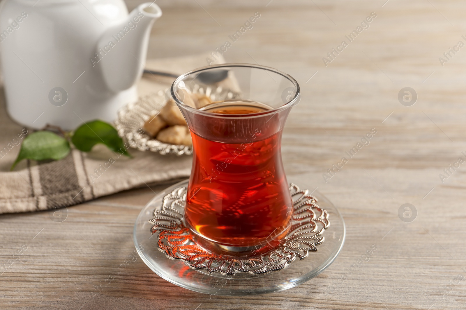 Photo of Glass of traditional Turkish tea on white wooden table, closeup