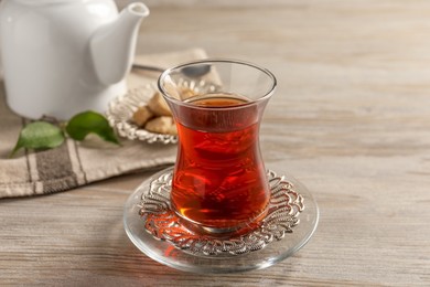 Photo of Glass of traditional Turkish tea on white wooden table, closeup