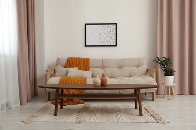 Living room with pastel window curtains, wooden table and sofa