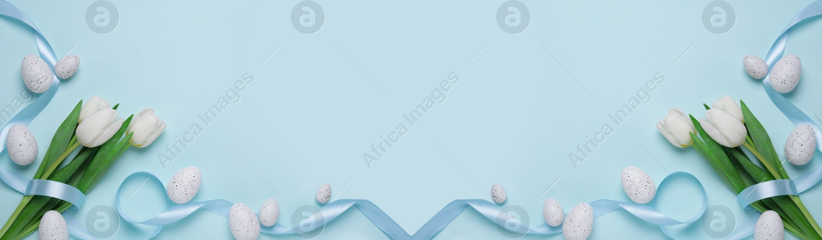 Image of Flat lay composition with decorated Easter eggs and flowers on pale light blue background, space for text. Banner design