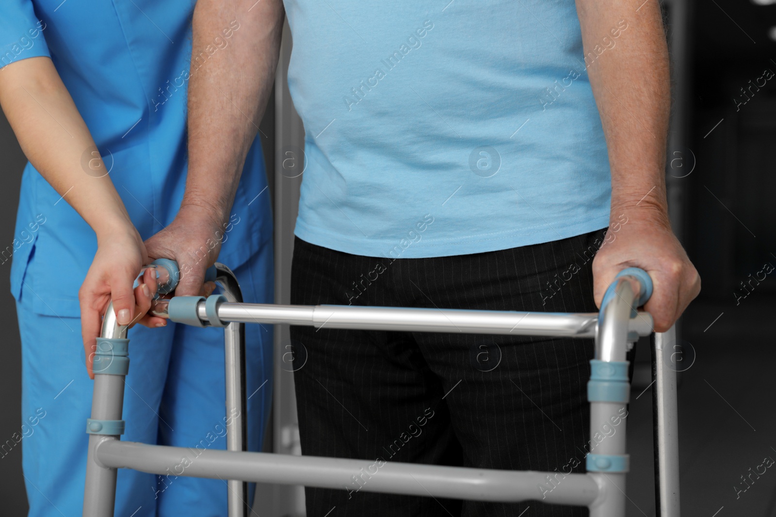 Photo of Nurse assisting senior patient with walker in hospital, closeup