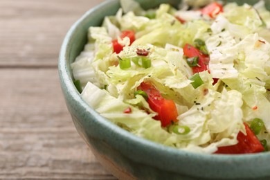 Photo of Tasty salad with Chinese cabbage, bell pepper and green onion in bowl on wooden table, closeup