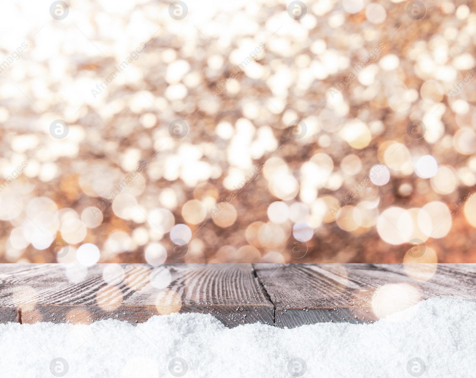 Image of Wooden surface with heap of snow and blurred Christmas lights on background, bokeh effect 