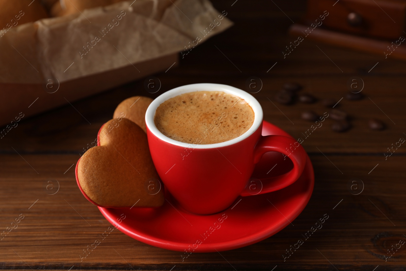 Photo of Delicious heart shaped cookies and cup of coffee on wooden table, closeup