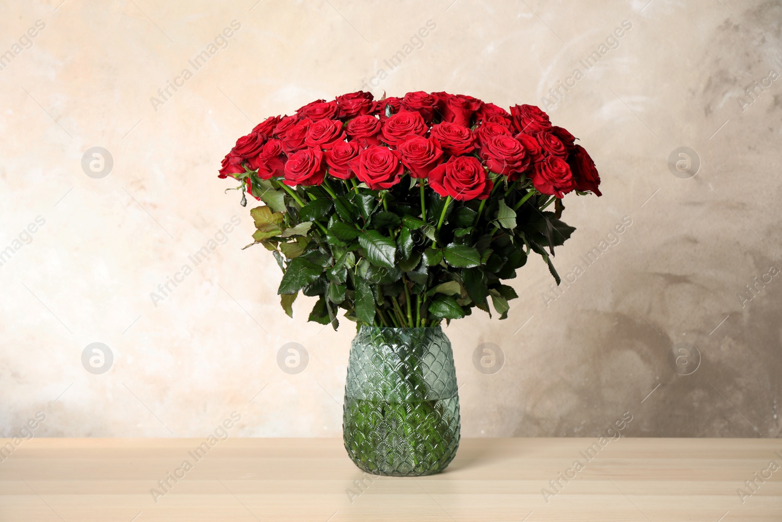 Photo of Luxury bouquet of fresh red roses on wooden table