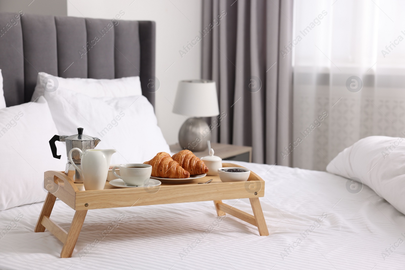 Tray with tasty breakfast on bed at home, space for text Photo of Tray with tasty breakfast on bed at home, space for text