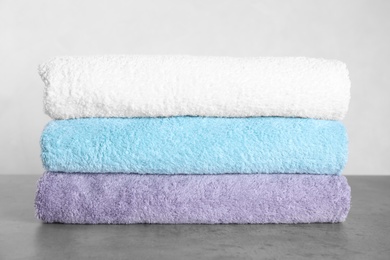 Photo of Stack of clean fresh towels on grey table