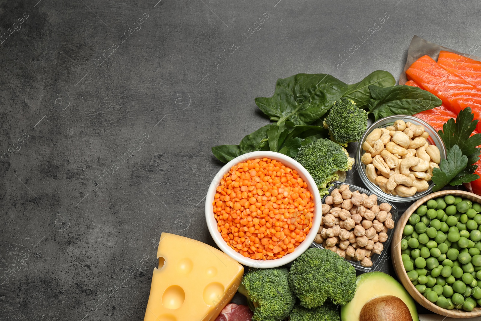 Photo of Products rich in protein on grey table, flat lay. Space for text