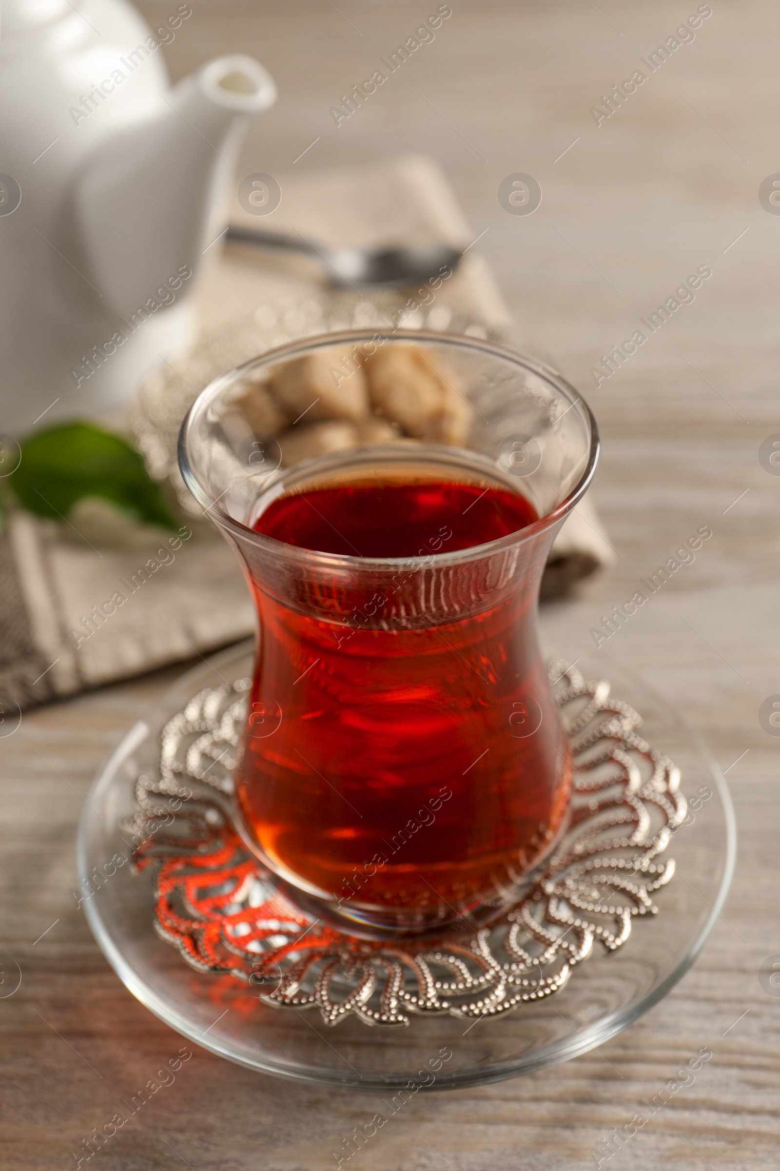 Photo of Glass of traditional Turkish tea on white wooden table, closeup