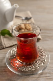 Photo of Glass of traditional Turkish tea on white wooden table, closeup