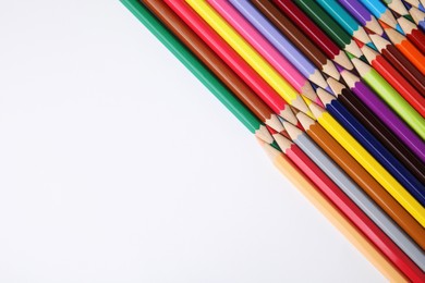 Colorful wooden pencils on white background, flat lay. Space for text