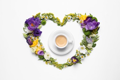 Beautiful heart made of different flowers and coffee on white background, top view