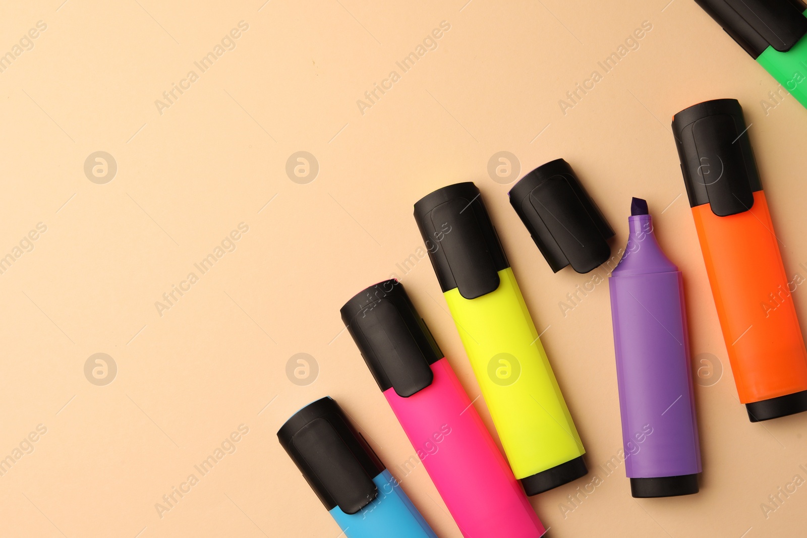 Photo of Bright color markers on beige background, flat lay. Space for text