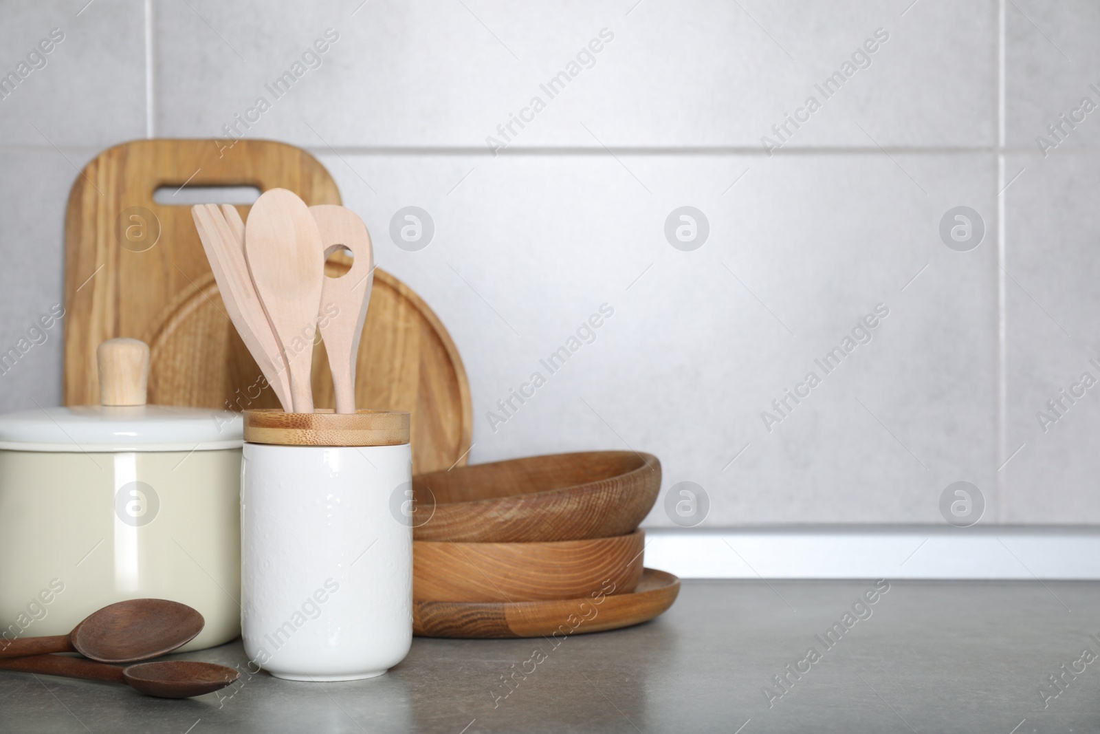 Photo of Cooking utensils and other kitchenware on grey countertop. Space for text