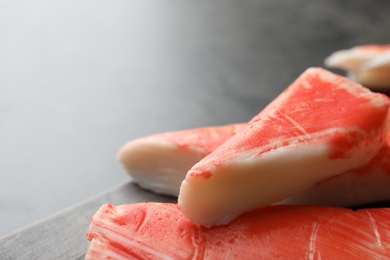 Delicious cut crab sticks on table, closeup. Space for text