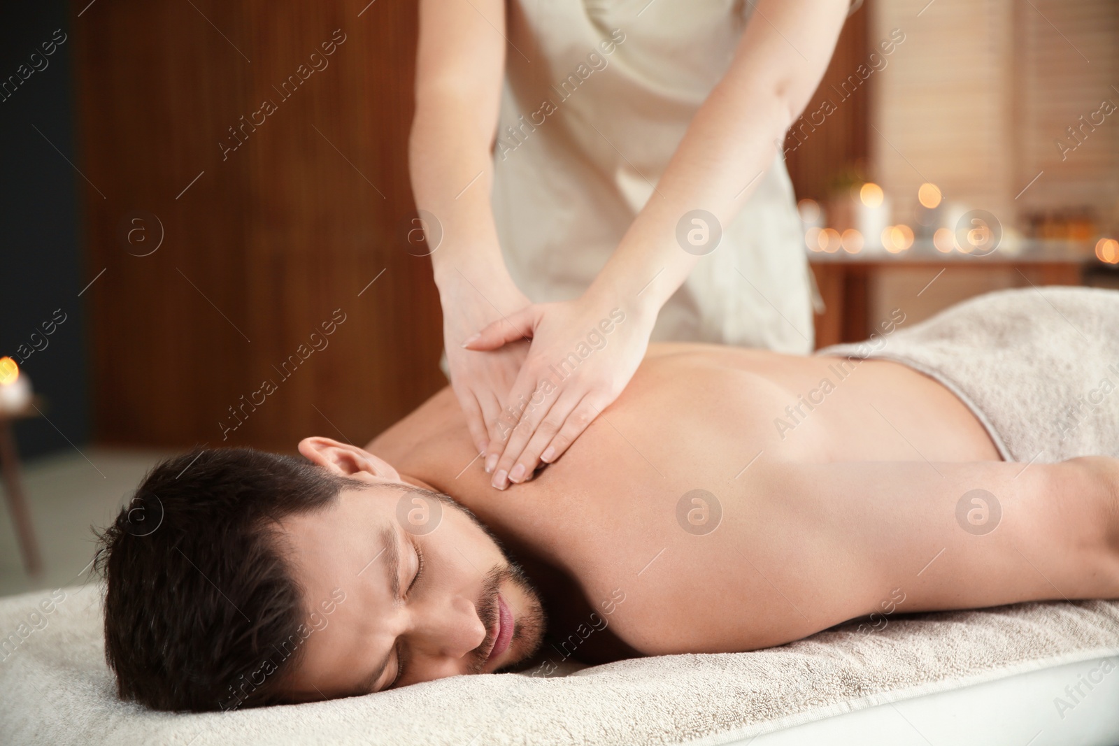 Photo of Handsome man receiving back massage in spa salon