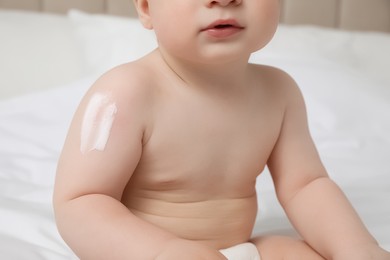 Photo of Cute little baby with cream on arm, closeup