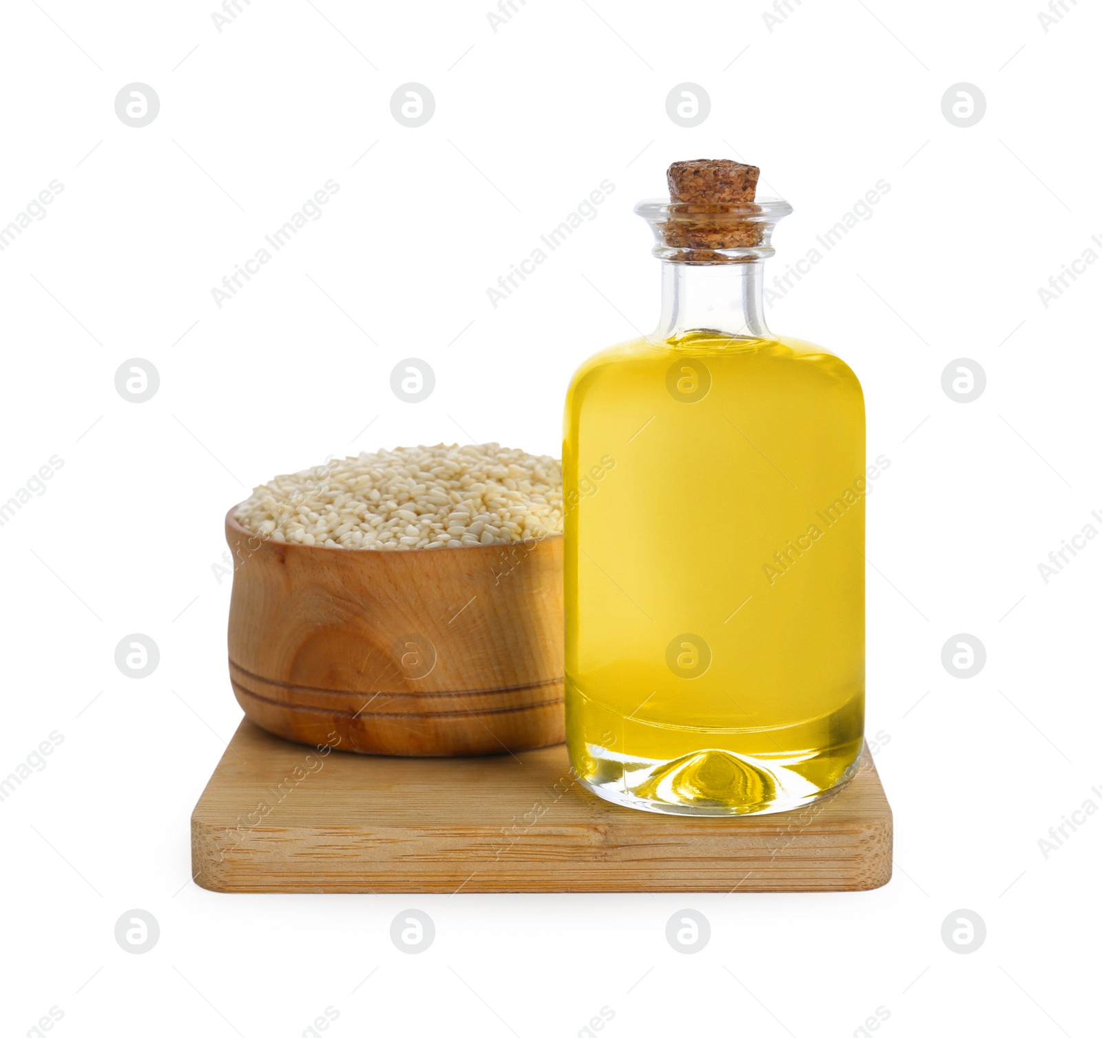 Photo of Glass bottle of fresh sesame oil and bowl with seeds isolated on white