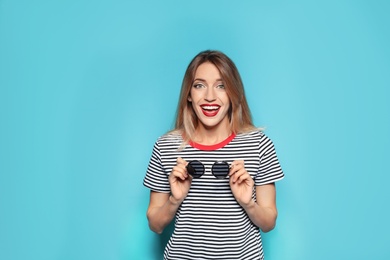 Beautiful young woman with healthy long blonde hair on color background