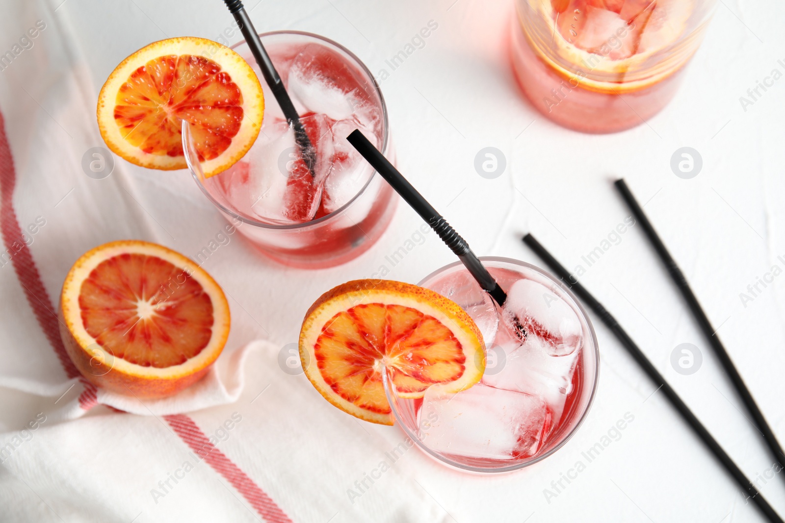 Photo of Composition with orange drink and ice cubes in glasses on table, top view