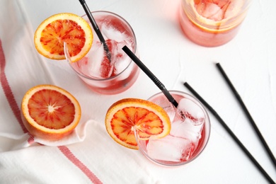 Composition with orange drink and ice cubes in glasses on table, top view