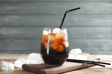 Photo of Composition with glass of refreshing cola on table