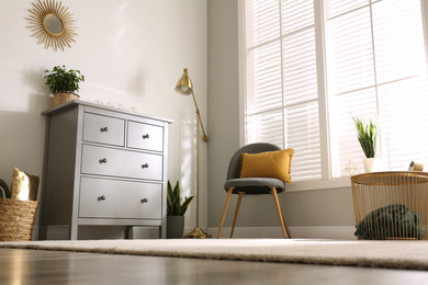 Grey chest of drawers in stylish room interior