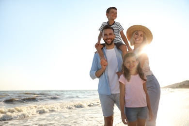 Photo of Happy family on beach near sea. Summer vacation