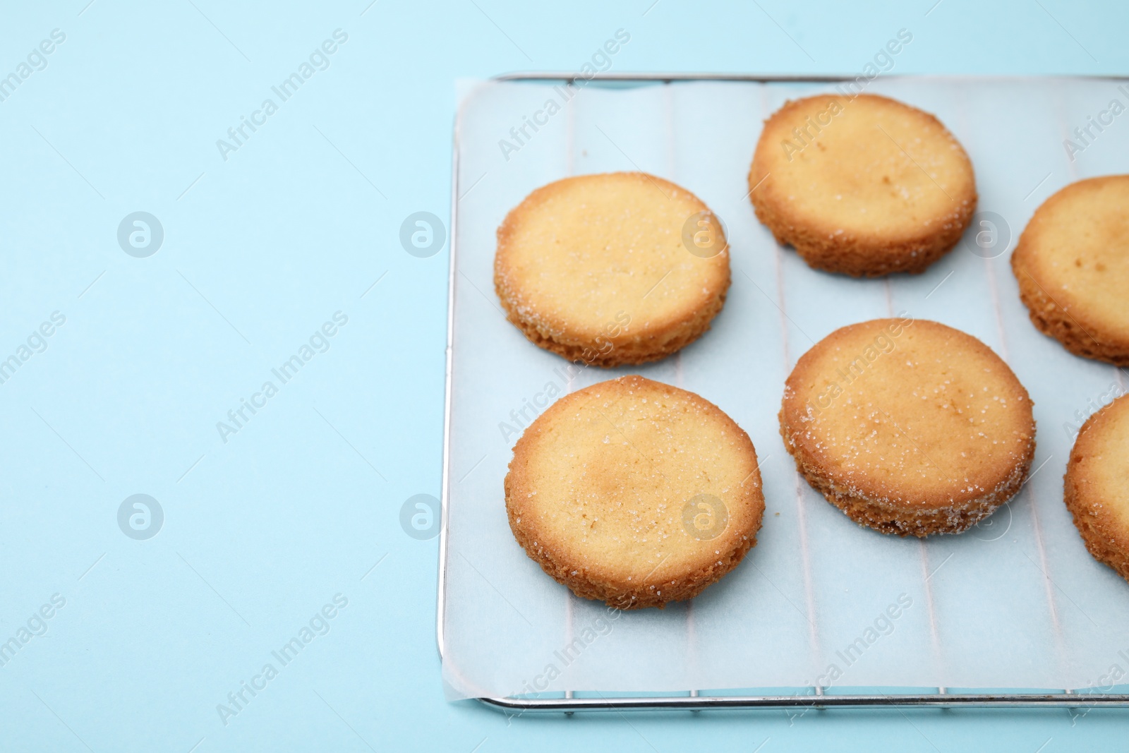 Photo of Tasty sweet sugar cookies on light blue background. Space for text