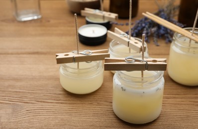 Glass jars with wax on wooden table, space for text. Handmade candles